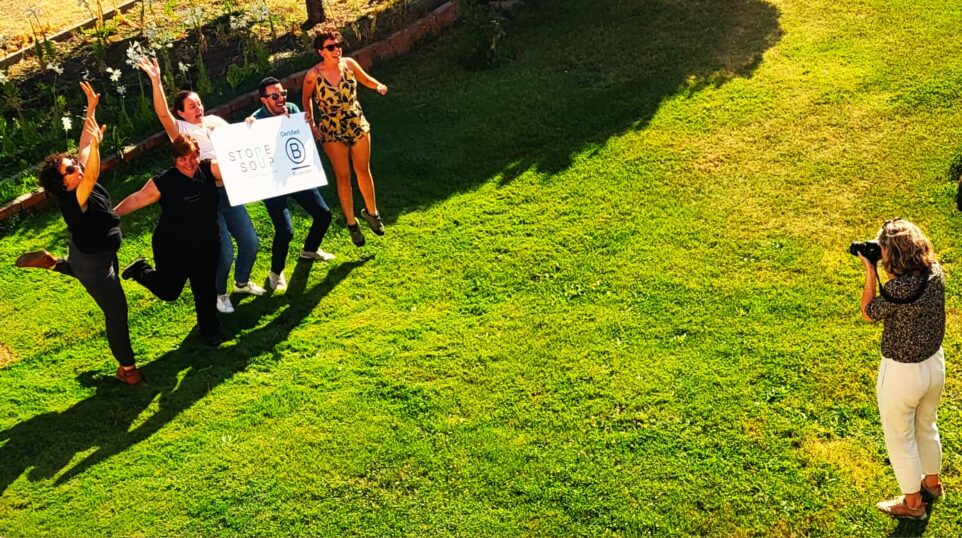 Consultant taking a picture of a team of community members holding a BCorp board