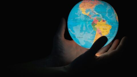 Two hands are holding the Earth globe
